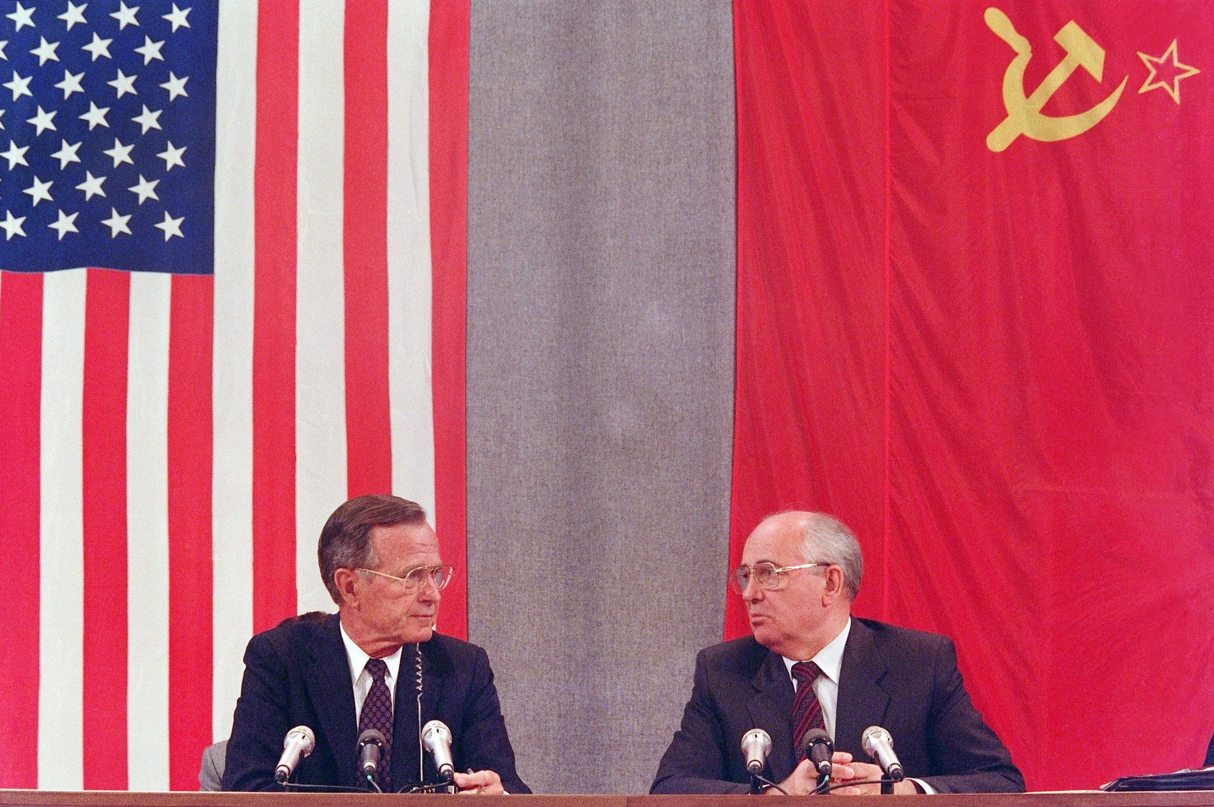 Mikhail Gorbatchov e George H. W. Bush com as respectivas bandeiras de seus países.